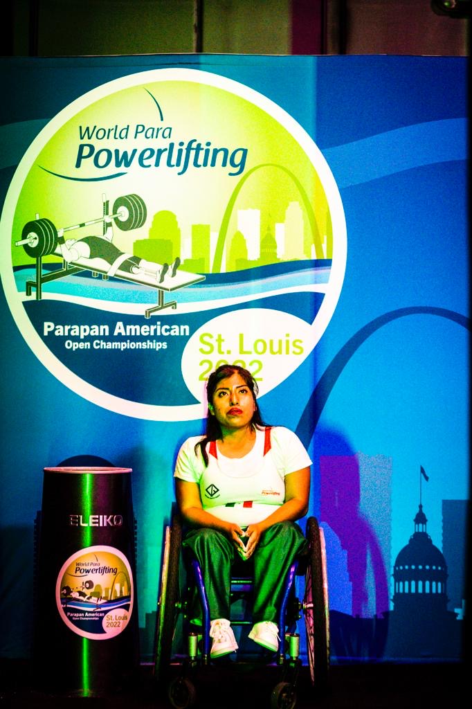 Female para powerlifter in a white national uniform at the St. Louis championship