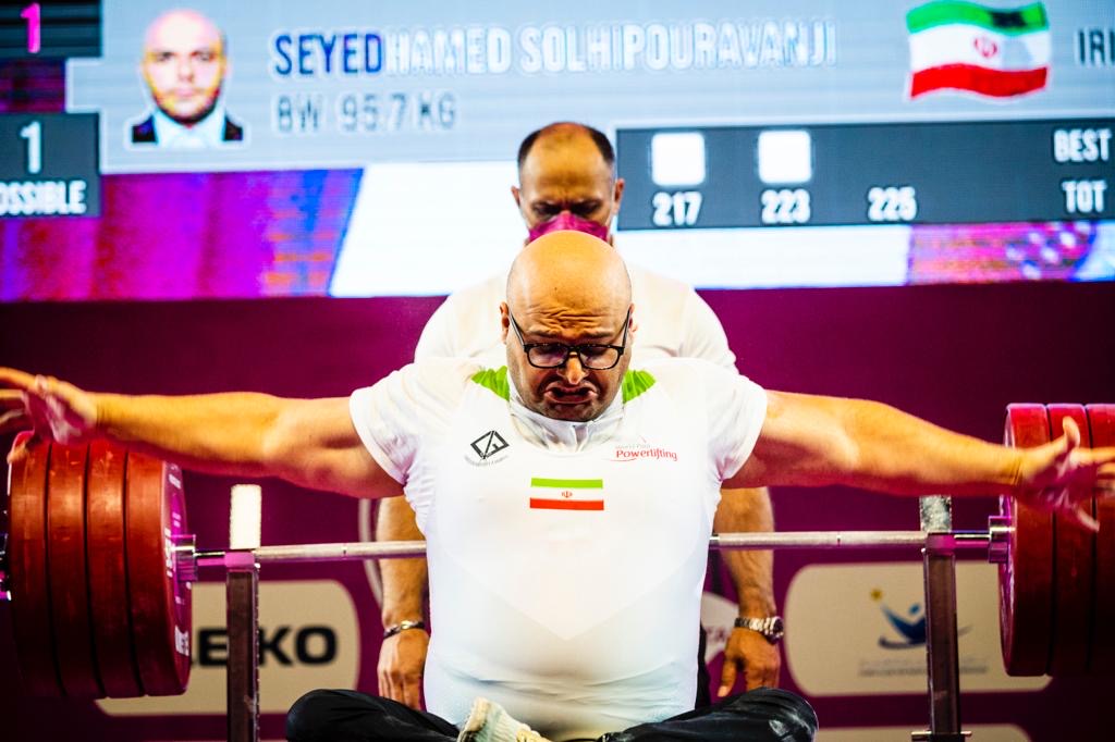 Iranian para powerlifter in a white national uniform preparing at the bench