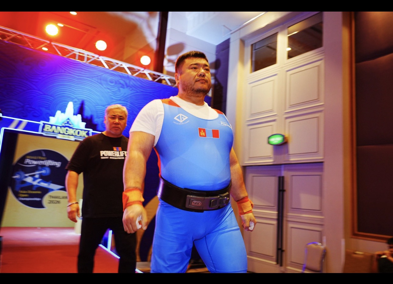 Para powerlifter in a blue competition suit entering the platform