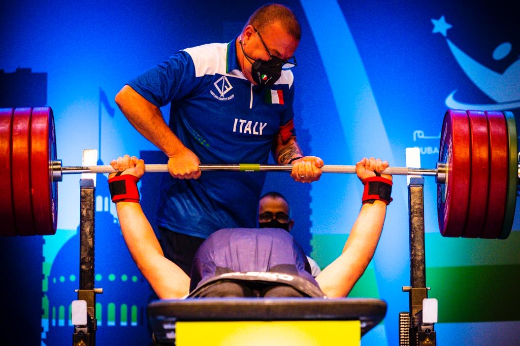 Para powerlifter at the bench with a spotter in an Italy team shirt