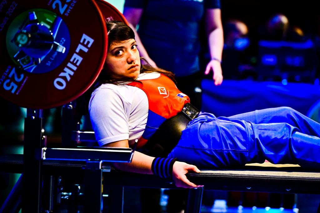 Chilean para powerlifter in a red and blue national uniform on the bench