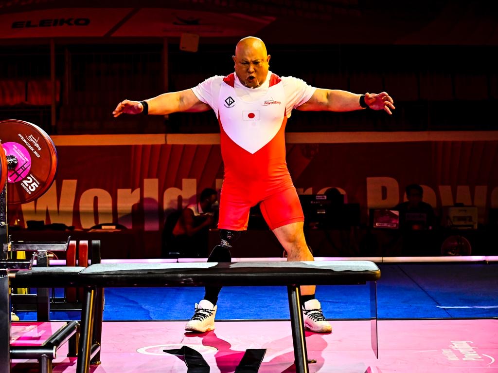 Japanese para powerlifter wearing a red and white national suit before an attempt