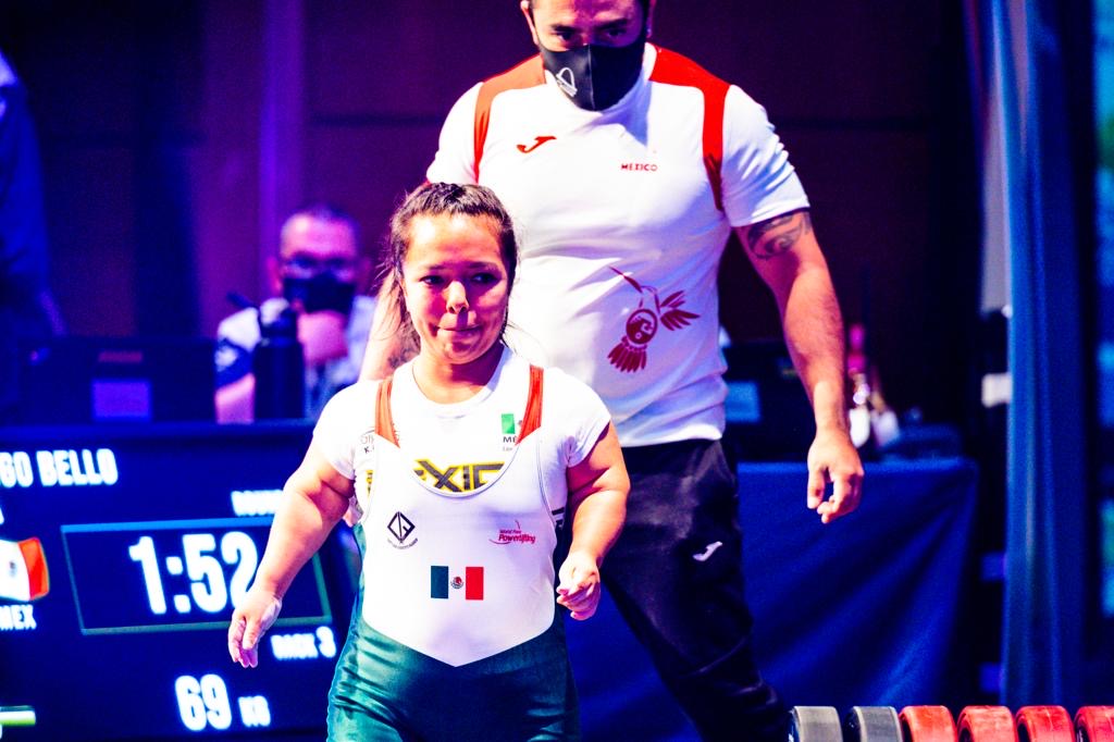 Mexican para powerlifter in a white and green national uniform approaching the platform